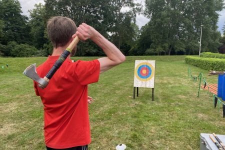 man participating in an axe throwing team building event
